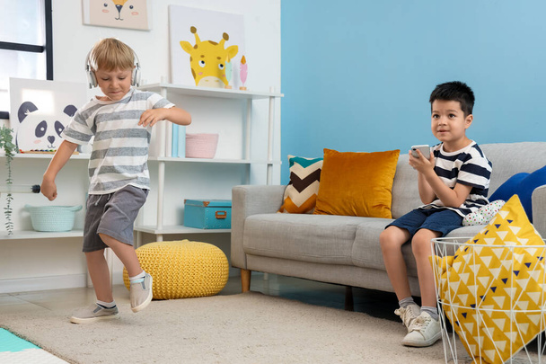 Χαριτωμένα μικρά αγόρια παίζουν με gadgets στο σπίτι - Φωτογραφία, εικόνα