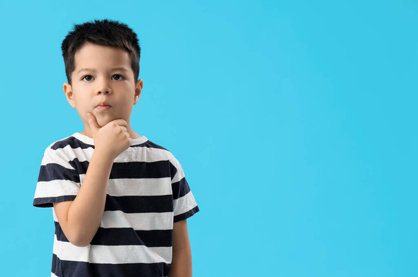 Thoughtful little boy on blue background - Photo, Image