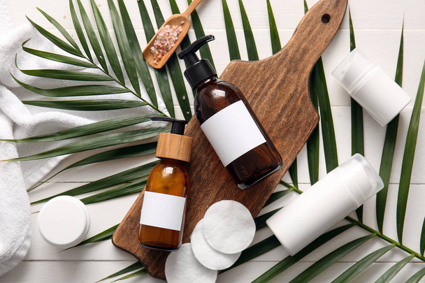 Bottiglie di shampoo e prodotti cosmetici su sfondo bianco in legno - Foto, immagini