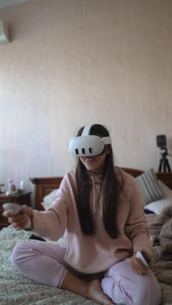 Se svou virtuální realitou sluchátka, okouzlující žena hraje videohry, zatímco v růžovém spacáku. Vysoce kvalitní 4K záběry - Záběry, video