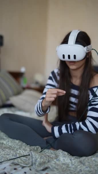 Avec un casque VR allumé, une charmante jeune femme aime le contenu vidéo. Images 4k de haute qualité - Séquence, vidéo