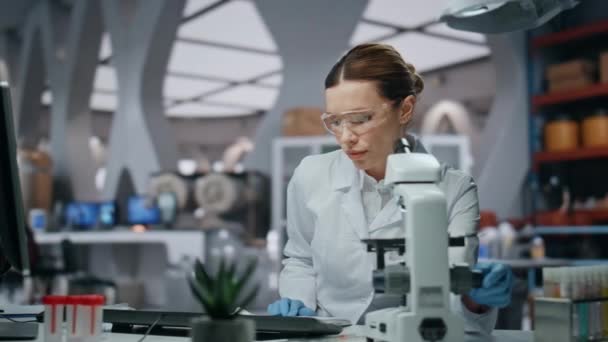 Ιατρικός ερευνητής ανάπτυξη έργου στο σύγχρονο εργαστήριο closeup. Σοβαρή γυναίκα επιστήμονας κρατώντας σημειώσεις βιοχημική έρευνα. Έξυπνη φαρμακευτική εξειδικευμένη σκέψη στη λύση καινοτομίας - Πλάνα, βίντεο