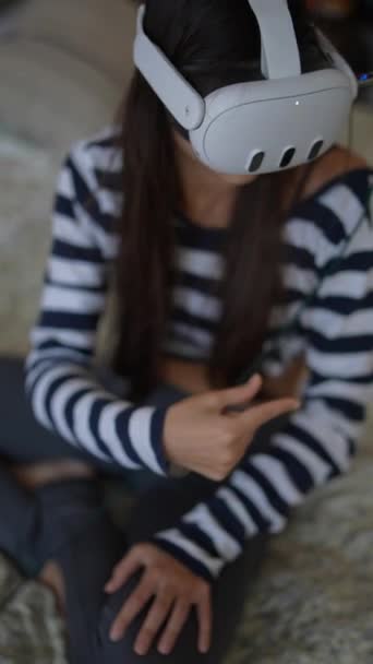Volledig geabsorbeerd in haar videospel, een jonge vrouw maakt verbinding met virtual reality technologie thuis. Hoge kwaliteit 4k beeldmateriaal - Video