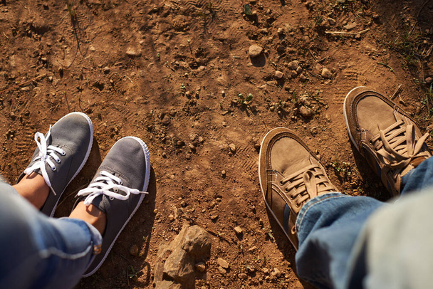 Dej si trochu špíny na boty. Vystřiženo vysoký úhel záběru dvou lidí stojící na prašné cestě - Fotografie, Obrázek