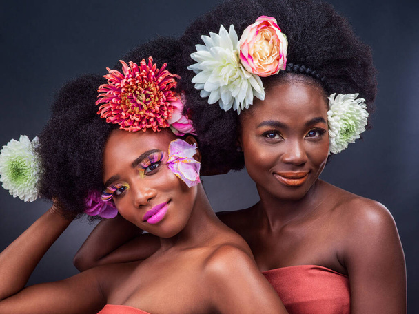 Δεν υπάρχει τέτοιο πράγμα όπως πάρα πολλά λουλούδια. δύο όμορφες γυναίκες ποζάρουν μαζί με λουλούδια στα μαλλιά τους - Φωτογραφία, εικόνα