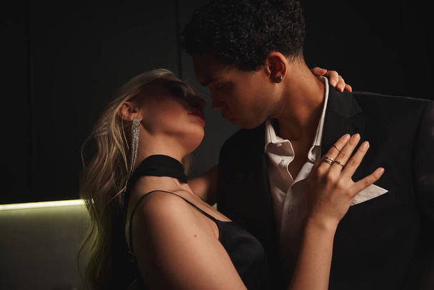 beau jeune couple multiracial en tenue de soirée se préparant à embrasser avec amour tandis que dans la cuisine - Photo, image