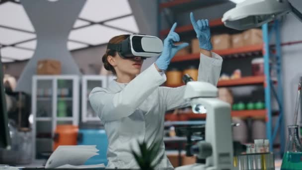 現代の実験室で仮想現実技術を研究しているゴーグルス科学者. 手でインターフェイスに触れるガラスの女性医師. 分析のために拡張現実を利用した医療研究者. - 映像、動画
