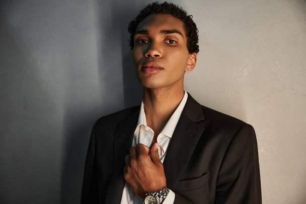 appealing handsome african american man in elegant suit with piercing in nose looking at camera - Photo, Image