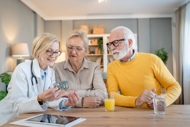 Mature woman doctor visit senior couple man and female husband and wife having a talk and consulting about diagnosis and medical medication treatment real people healthcare concept copy space - Photo, Image