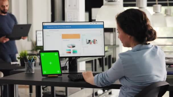 Manažer používá zelenou obrazovku na tabletu v kooperačním prostoru kanceláře, prezentovat izolované copyspace layout na moderní gadget. Podnikatelka používající PC desktop a chromakey obrazovku na stole. Ruční snímek. - Záběry, video