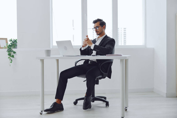 Ο άνθρωπος στο γραφείο επιχειρηματίας κάθεται στο γραφείο και εργάζονται σε φορητό υπολογιστή, τα οικονομικά και την εκκίνηση έννοια, τρόπο ζωής εργασίας σε φωτεινό γραφείο. Υψηλής ποιότητας φωτογραφία - Φωτογραφία, εικόνα