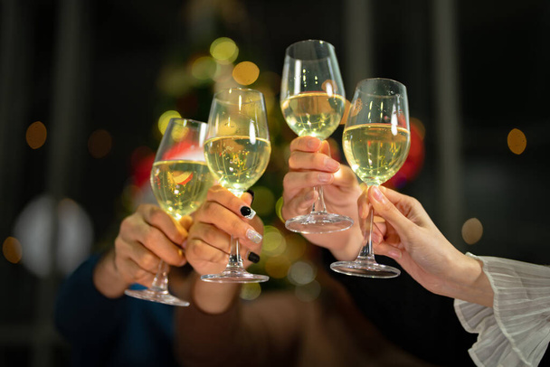 Закрыть бокалы звенящих бокалов шампанского светом. Ужин с шампанским. руки держат прозрачное стекло с алкоголем в желтом блеске отражают. - Фото, изображение
