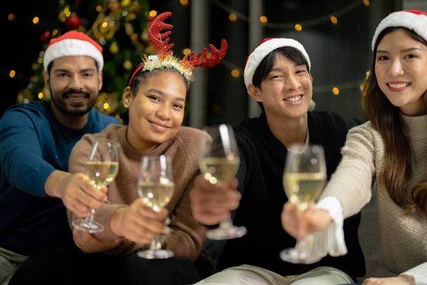 Csukja be a poharakat pezsgővel és világítással. A párt ázsiai barátja nő és férfi ünnepel. boldogság barátok karácsony este ünnepeljük vacsora party étellel és pezsgővel. - Fotó, kép