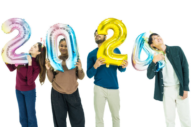 Bir grup insan yeni yıl için 2024 sayısının fantezi renkli balonlarını tutuyor. Beyaz arka planda duran kadın ve erkekler. Mutlu yıllar partisi. - Fotoğraf, Görsel