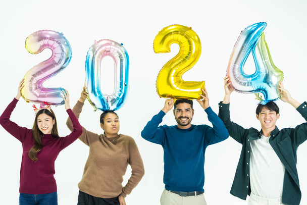 skupina lidí, kteří drží fantasy barevné balónky bublina čísla 2024 na nový rok. muži a ženy stojící na bílém pozadí. oslava šťastného nového roku Party - Fotografie, Obrázek
