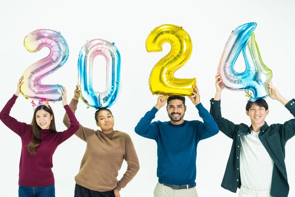 група людей, що тримають кульки фантастичного кольору номером 2024 на Новий рік. чоловіки і жінки, що стоять на білому тлі. святкування щасливого новорічного свята - Фото, зображення
