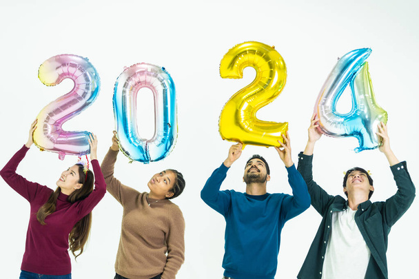 ファンタジーカラーの気球バブルを開催する人々のグループ 2024 新年のために. 白い背景に立っている男女. ハッピーニューイヤーパーティーのお祝い - 写真・画像