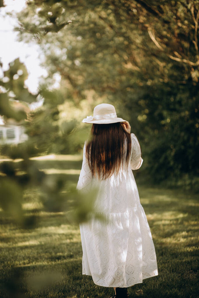 νεαρή γυναίκα με λευκό φόρεμα σε πάρκο - Φωτογραφία, εικόνα