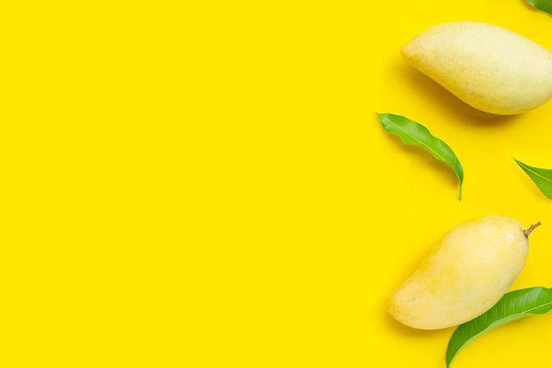 Tropik meyve, sarı arka planda mango. Üst görünüm - Fotoğraf, Görsel