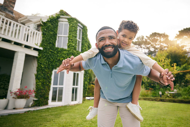 Father, child and piggyback outdoor or garden for real estate happiness, celebration and game at new house. Dream home, freedom and excited child with dad on lawn running and flying on property. - Photo, Image
