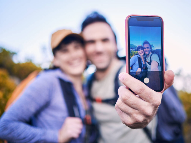 Escursioni, natura e coppia con selfie sullo schermo per avventura, vacanza e viaggio in montagna. Viaggi, incontri e felice uomo e donna scattare foto al telefono per esplorare, trekking e zaino in spalla. - Foto, immagini