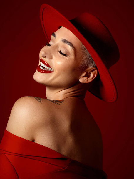 Мода, смішна і модель жінка на червоному фоні студії для елегантного або модного стилю. Естетика, мистецтво і краса з молодою жінкою, яка сміється в вихровій або стильній унікальній одязі. - Фото, зображення