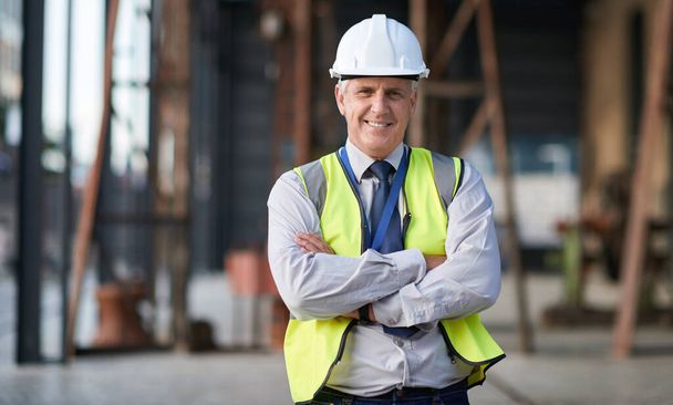 Portrait of senior engineer man at a construction site outdoor for building project management. Face of happy contractor person with helmet for civil engineering, safety and development with vision. - Фото, изображение