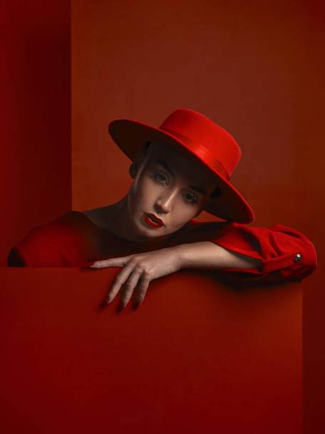 Moda, retrato y una mujer vintage sobre un fondo rojo para una estética sexy o creativa. Retro, rico y un modelo elegante, elegante o con estilo o chica con cosméticos aislados en un fondo de estudio. - Foto, imagen