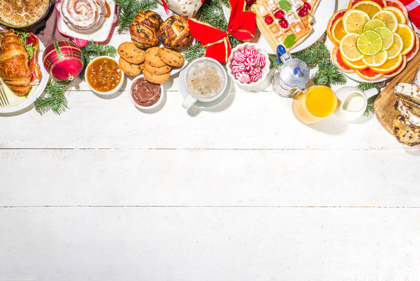 Slavnostní vánoční snídaně nebo svačinový stůl, s tradičními pokrmy palačinka, belgická vafle, smažená vejce, croissant, ukradené, sušenky, s pomerančovým džusem a kávou, skořicová rýžová kaše  - Fotografie, Obrázek