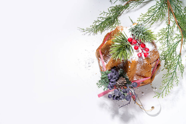 Bolo de frutas tradicional italiano de Natal Panettone Pandoro com fita vermelha festiva e decorações de Natal, no fundo branco, espaço de cópia
 - Foto, Imagem