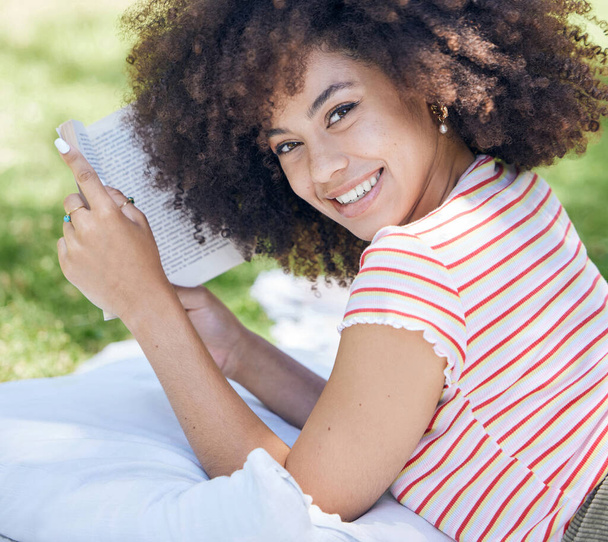 Mosolyogj könyvvel, olvasással és fekete nővel a parkban piknikezni egy takaróval a szabadban a természet portréján. Boldog, fiatal, pihentető és hobbik, tavaszi szünetben tanul - Fotó, kép