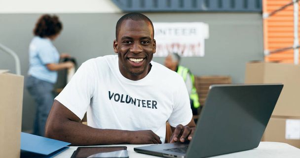 Voluntario, portátil y retrato para donación, unidad de ropa y sonrisa para el servicio comunitario, pergamino y web. Persona africana, PC y responsabilidad social con cajas, caridad e ideas para ayudar. - Foto, imagen