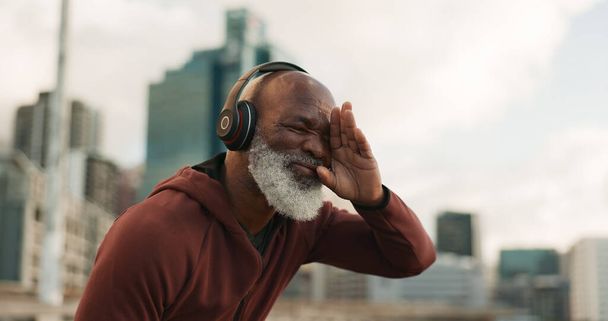 Senior, γυμναστήριο και κουρασμένος άνθρωπος σε μια πόλη με ακουστικά μουσικής για έντονη, καρδιο ή προπόνηση υπαίθρια Αθλητισμός, κούραση και ηλικιωμένους άνδρες δρομέας στάση για διάλειμμα, αναπνοή και εφίδρωση από τρέξιμο προπόνηση. - Φωτογραφία, εικόνα