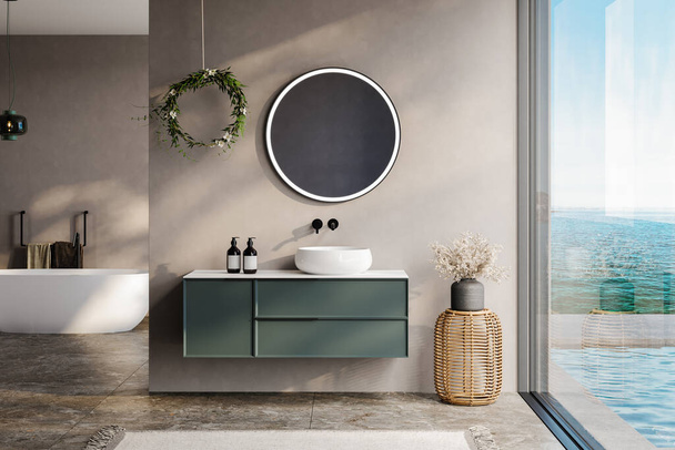 modern bathroom with beige and soil tone walls, white bathtub, green vanity, black mirror, sink, terrazzo floor, and a view of the pool and sea from the window - Photo, Image