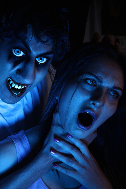A halloween image of vampire holding his victim by her neck, - Photo, Image