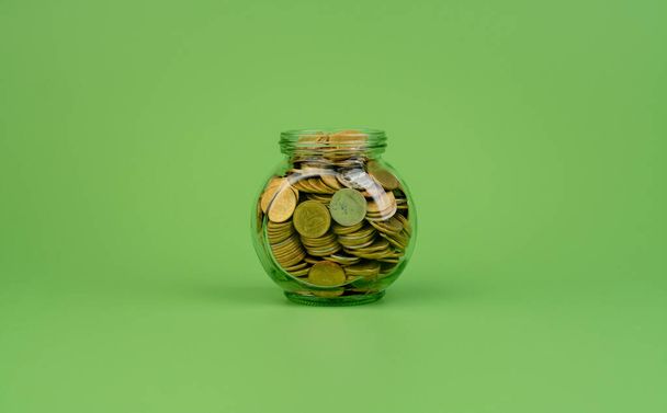 Ahorro de monedas en un frasco de vidrio Finanzas e inversión financiera, banco de monedas, salario, salarios, flujo de caja - Foto, imagen