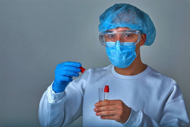 Medico in maschera che esegue esami del sangue per coronavirus COVID19, HIV, ebola o altre infezioni pericolose. sfondo medico, modello, carta da parati. Concetto di malattia di Coronavirus
 - Foto, immagini