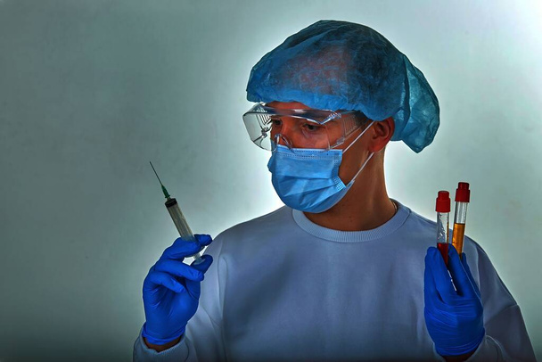 Médecin masqué effectuant un test sanguin pour le coronavirus COVID19, le VIH, le virus Ebola ou toute autre infection dangereuse. Fond médical, modèle, papier peint. Concept de maladie à coronavirus
 - Photo, image
