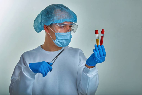 Medico in maschera che esegue esami del sangue per coronavirus COVID19, HIV, ebola o altre infezioni pericolose. Sfondo medico, strumenti, modello, carta da parati. Concetto di malattia di Coronavirus
 - Foto, immagini