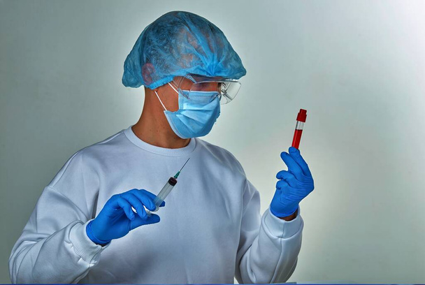 Lékař v masce, který drží zkumavky, koronavirus COVID19, HIV, ebolu nebo jinou nebezpečnou infekci. Lékařské zázemí, nástroje, šablony, tapety. Koncept koronavirové choroby. Portrét doktora - Fotografie, Obrázek