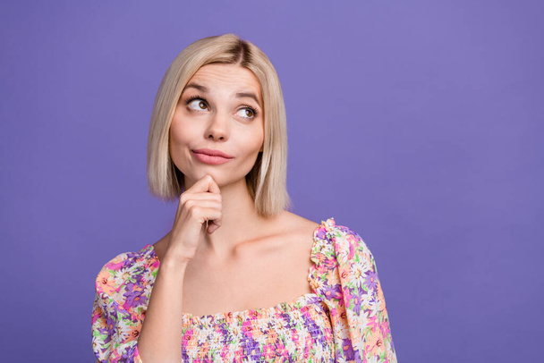 Photo of positive unsure lady wear flower print top arm chin looking empty space isolated violet color background. - Foto, Imagem