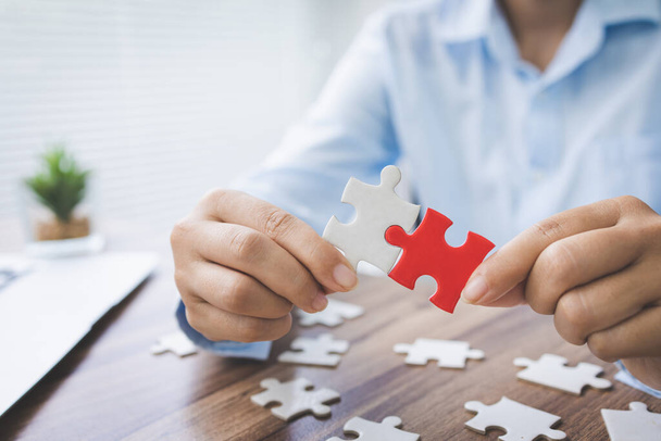 person hand connecting jigsaw puzzle pieces, business solutions, goals, success, goals and strategy concept, teamwork concept. - Photo, Image