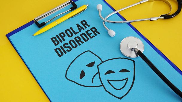 Bipolare Störung wird anhand eines Textes und eines Bildes mit glücklichen und traurigen Masken dargestellt - Foto, Bild