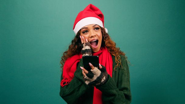 Όμορφη νεαρή γυναίκα παίρνει καλά νέα τα Χριστούγεννα, συγκλονισμένος ενθουσιασμός, στούντιο. Υψηλής ποιότητας φωτογραφία - Φωτογραφία, εικόνα