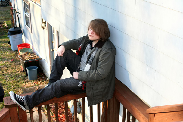 Teen Sitting on Railing
 - Фото, изображение