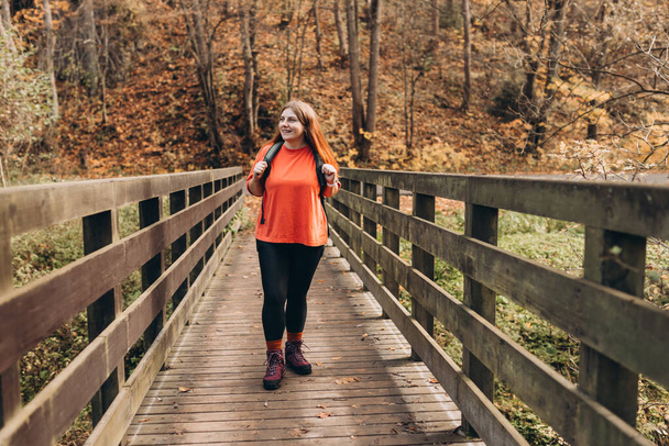 Heureuse femme qui marche dans les bois. Randonnée touristique active portant un sac à dos en plein air trekking en forêt. - Photo, image