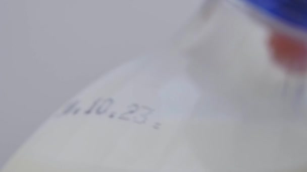 Close-up de uma garrafa de leite com uma data de validade do produto lácteos. - Filmagem, Vídeo