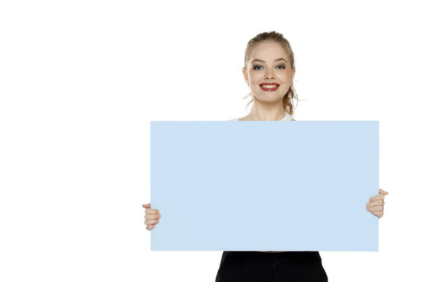 Banner of young happy blonde woman feeling happiness and holding blue Empty white canvas frame for text or advertising isolated on white studio background - Photo, Image