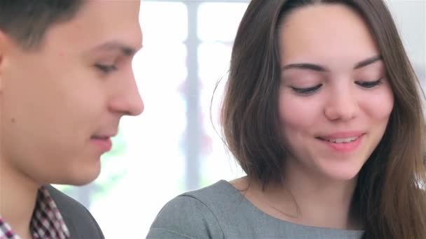 Close-up gezicht jonge aantrekkelijke zakelijke man en vrouw discussiëren over het verzamelen van gegevens op de Tablet, meisje glimlachend - Video