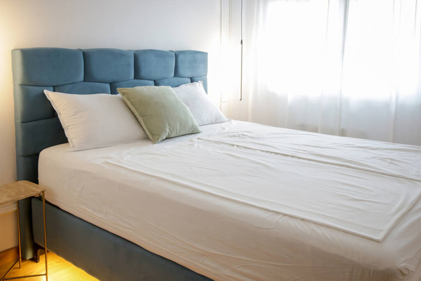 Camera da letto accogliente ed elegante. Letto king size blu con biancheria da letto in cotone bianco. - Foto, immagini